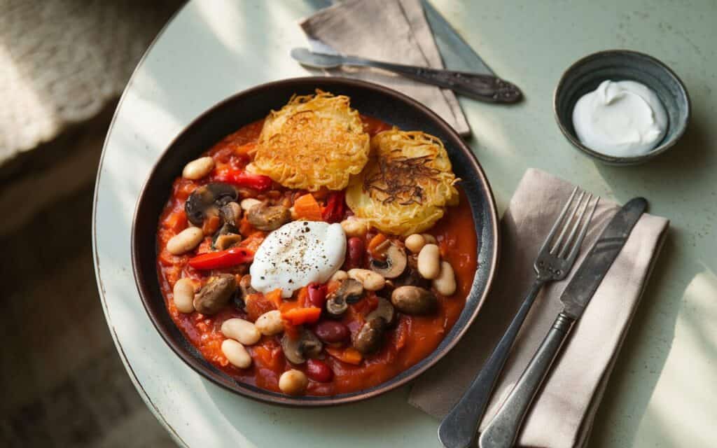 Wegetariański gulasz z plackami ziemniaczanymi i kwaśną śmietaną